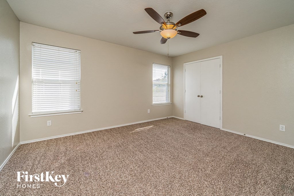 the living room of an empty house with a ceiling fan