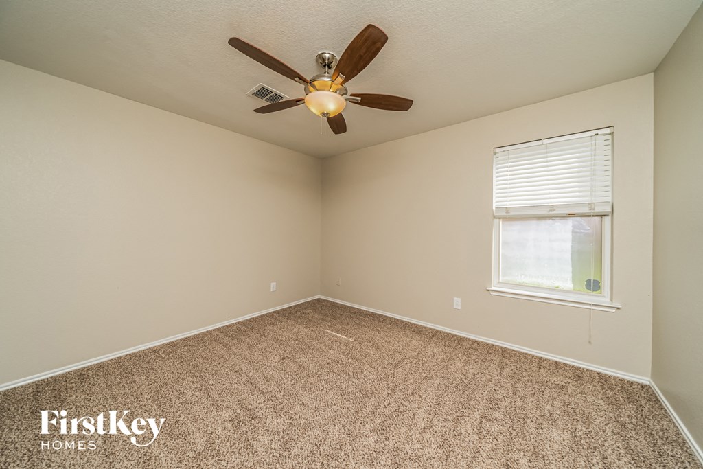 a bedroom with a ceiling fan and a window