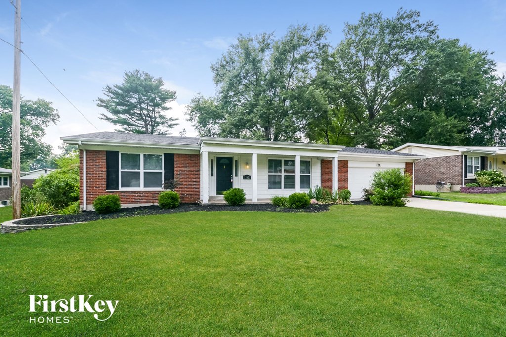 a small brick house with a lawn in front of it