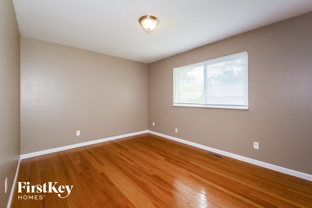 the second bedroom with hardwood flooring and a large window