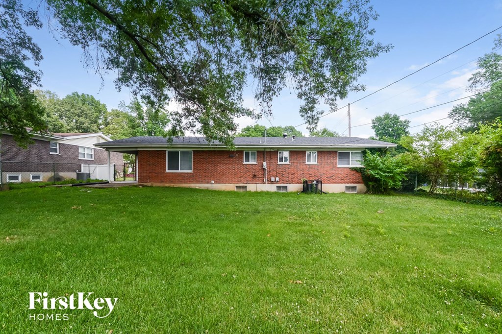 a red brick house with a large yard and green grass