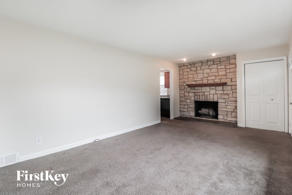 A room with a fireplace and a door on the right side.