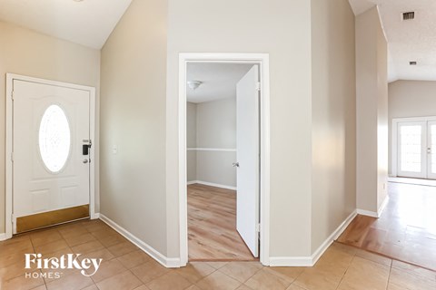 an empty hallway with a door to a bedroom and a door into a hall way
