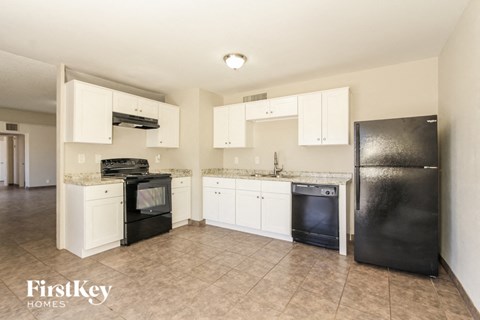 A kitchen with black appliances and white cabinets.