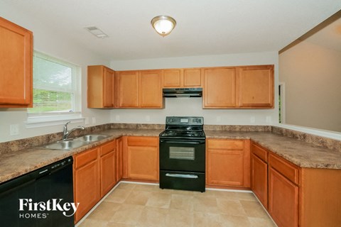 A kitchen with brown cabinets and a black stove top oven.