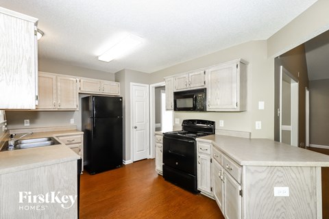 A kitchen with wooden cabinets and black appliances.