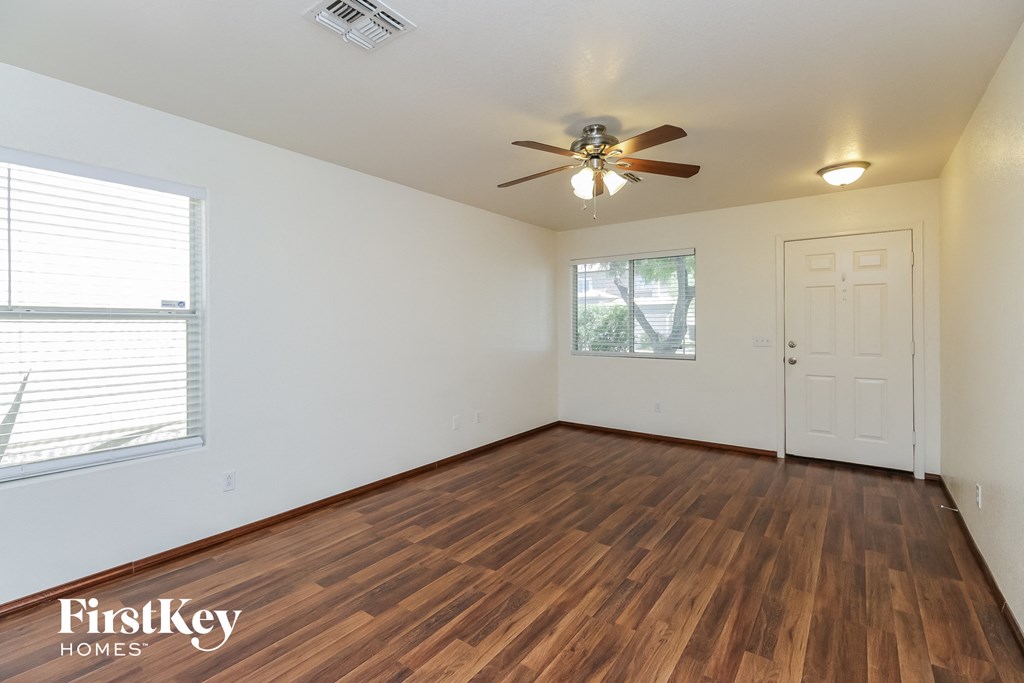 A room with wooden flooring and a ceiling fan.