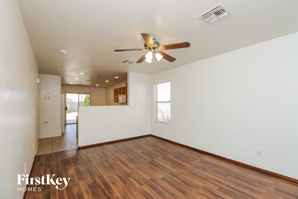 A room with a wooden floor and a ceiling fan.