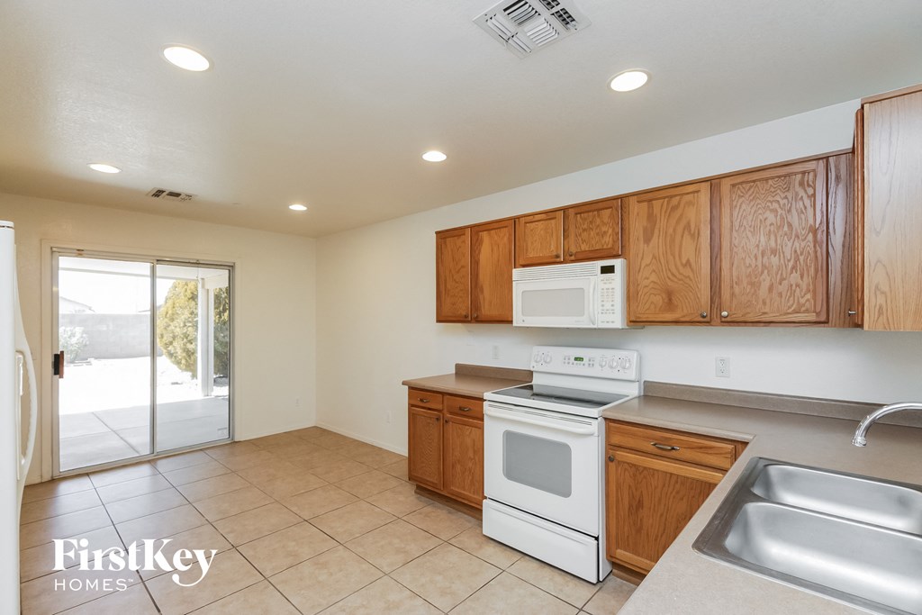 A kitchen with wooden cabinets and a white stove top oven.