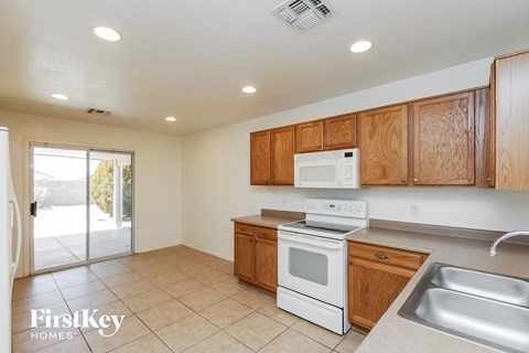 A kitchen with wooden cabinets and a white stove top oven.