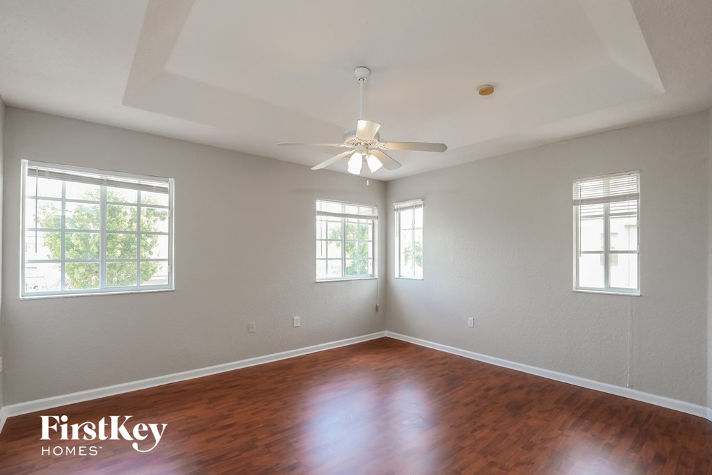 a living room with wood floors and a ceiling fan