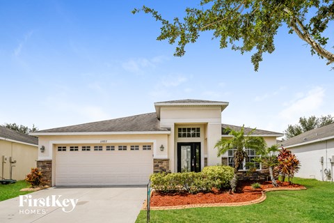 a white house with a garage door and a lawn