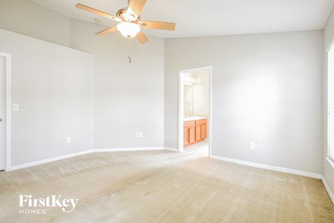 a living room with white walls and a ceiling fan