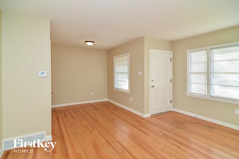 a living room with a wooden floor and a white door