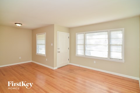 a living room with a wooden floor and a window and a door