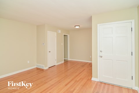 a bedroom with wood floors and a white door