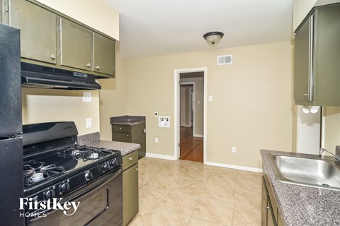 a kitchen with granite counter tops and stainless steel appliances and a stove top oven