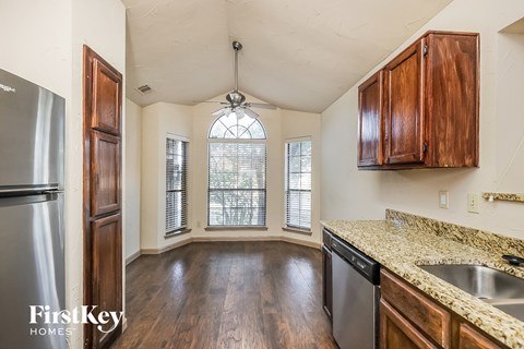 A kitchen with wooden cabinets and a stainless steel refrigerator.