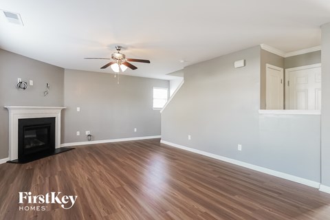A spacious living room with a fireplace and wood flooring.