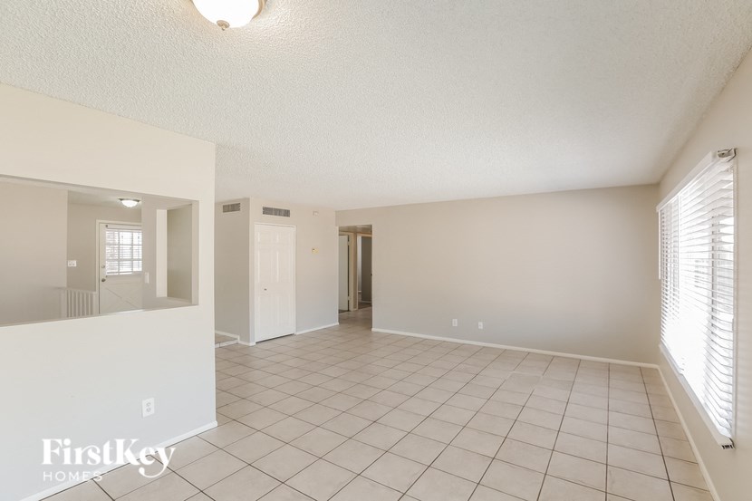 the living room and dining room of a house with a tiled floor