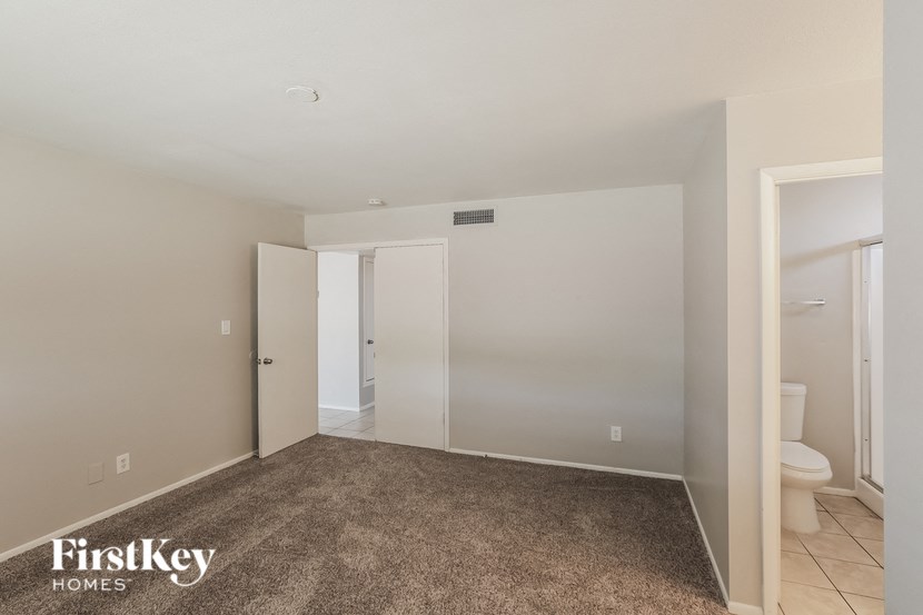 a carpeted room with a bathroom and a toilet