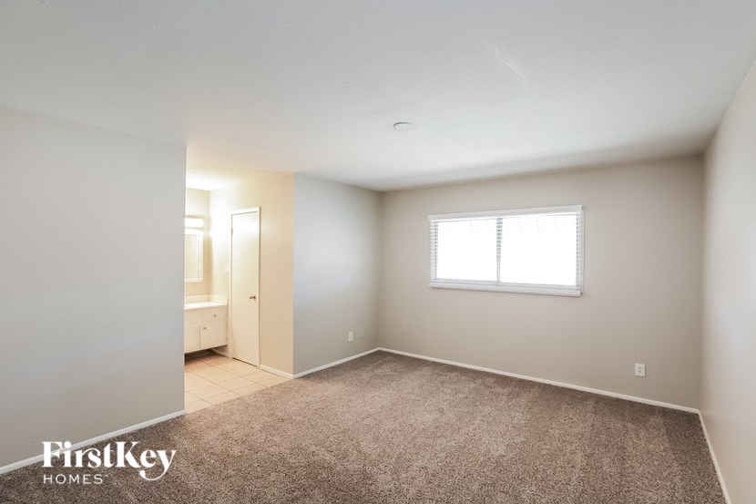 a bedroom with a carpeted floor and a window