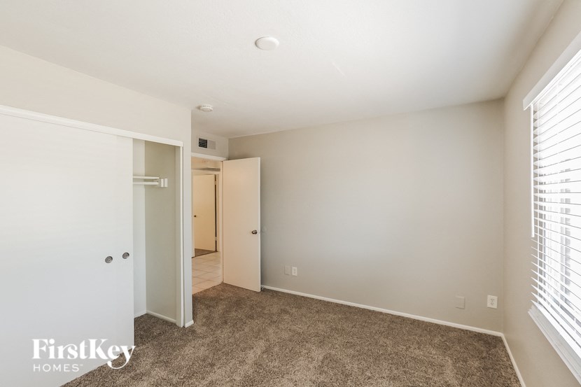 a bedroom with a closet and a door to a bathroom