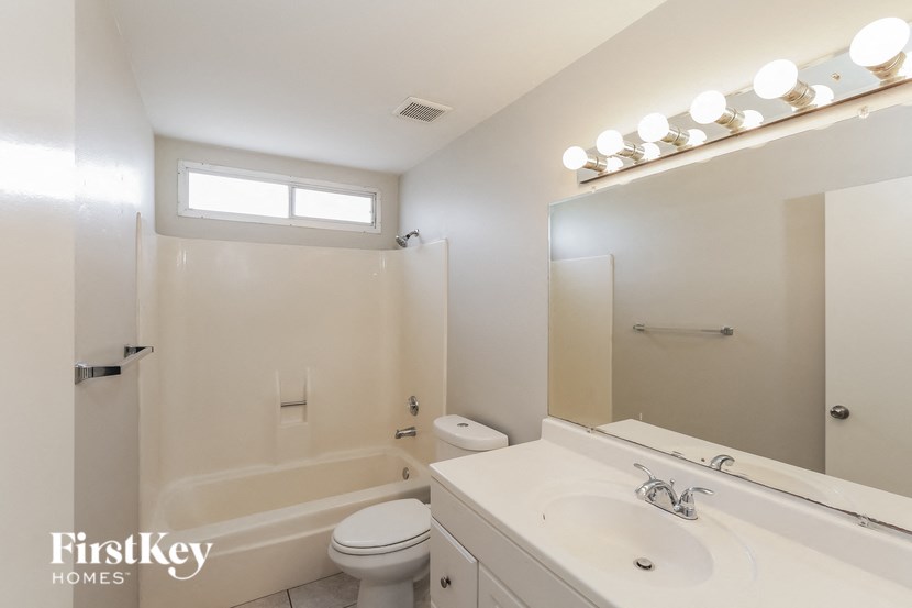 a white bathroom with a toilet sink and a mirror
