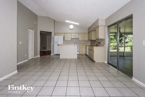 a large kitchen with white cabinets and a sliding glass door