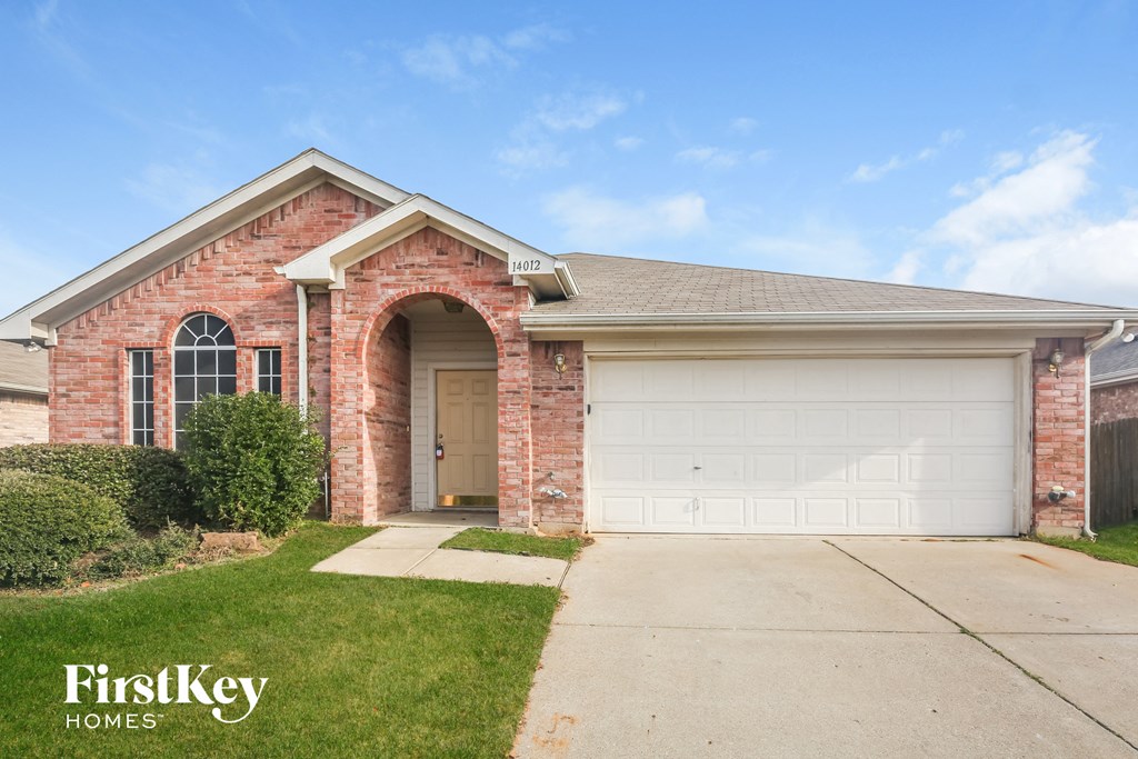 A brick house with a garage door and a window.