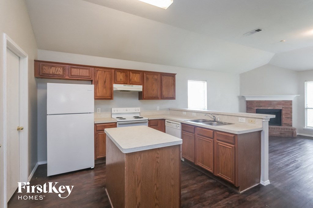 A kitchen with wooden cabinets and a white fridge.