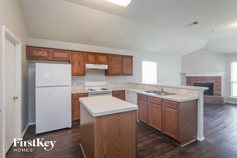 A kitchen with wooden cabinets and a white fridge.