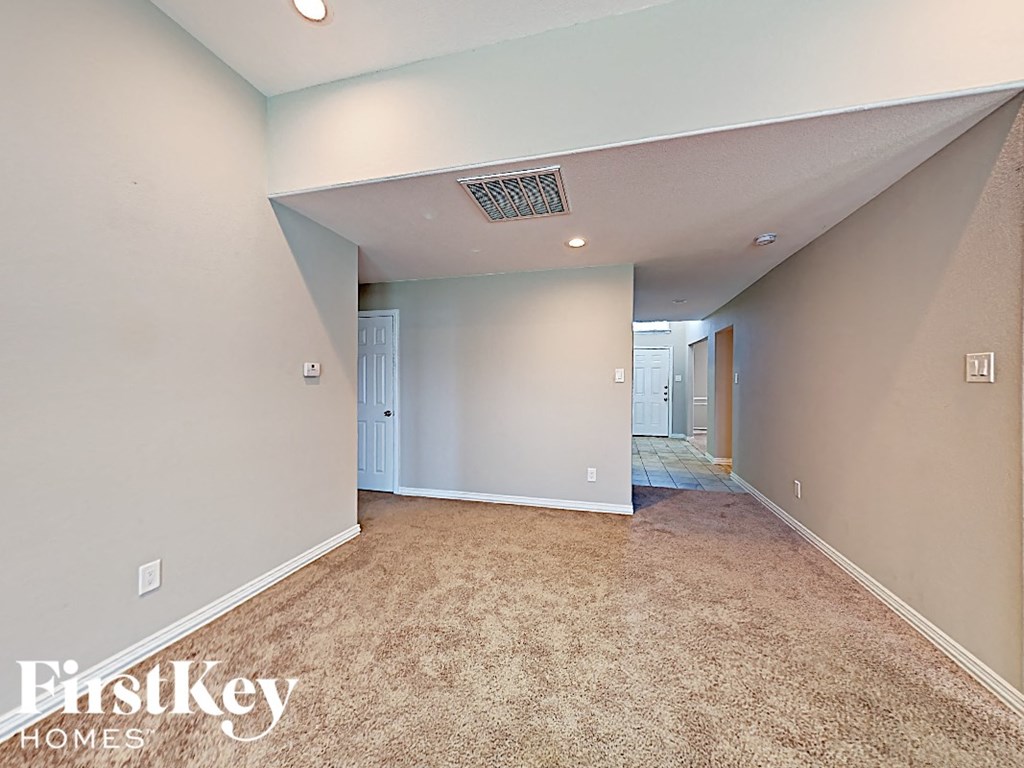 A room with a carpeted floor and a white door.
