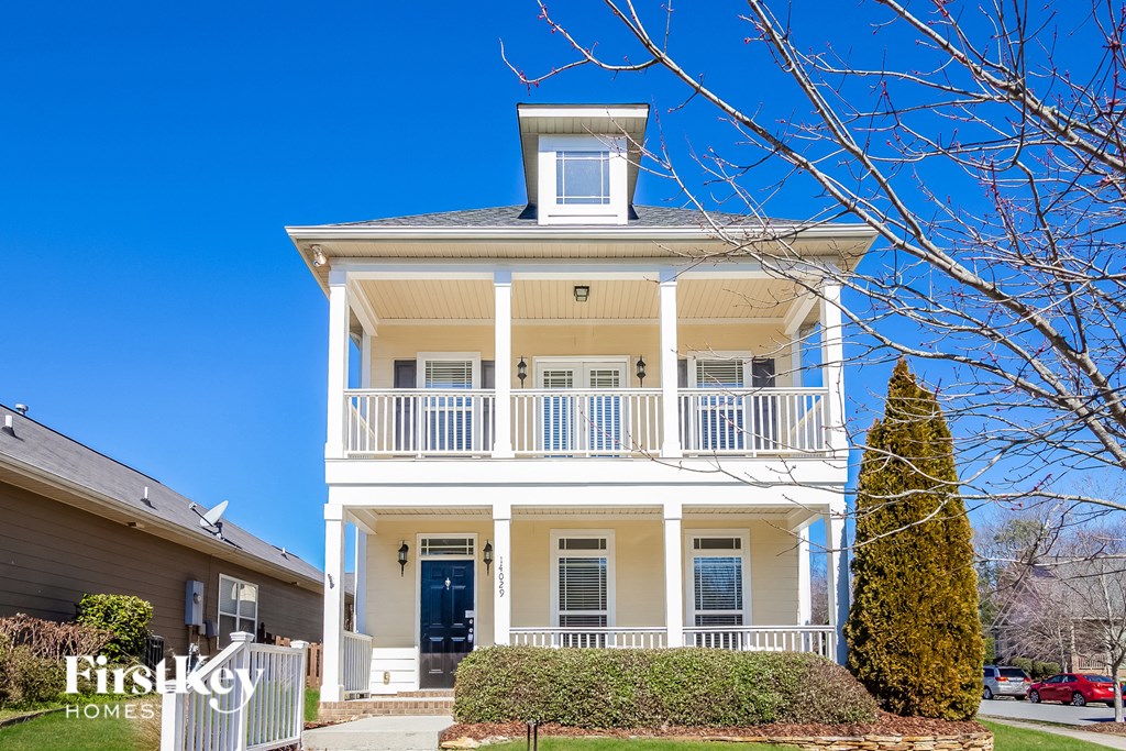 A two-story house with a balcony and a blue trim.