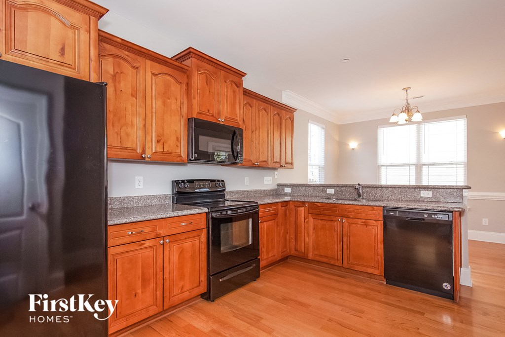 A kitchen with wooden cabinets and black appliances.