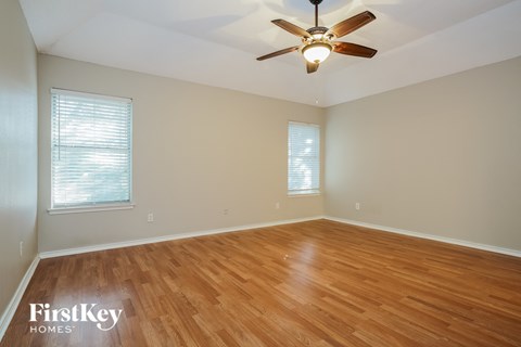 a living room with wood floors and a ceiling fan
