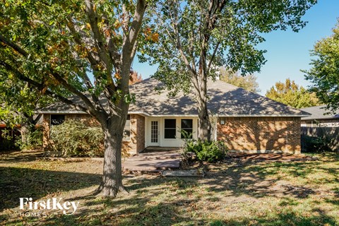 a small brick house with trees in the yard