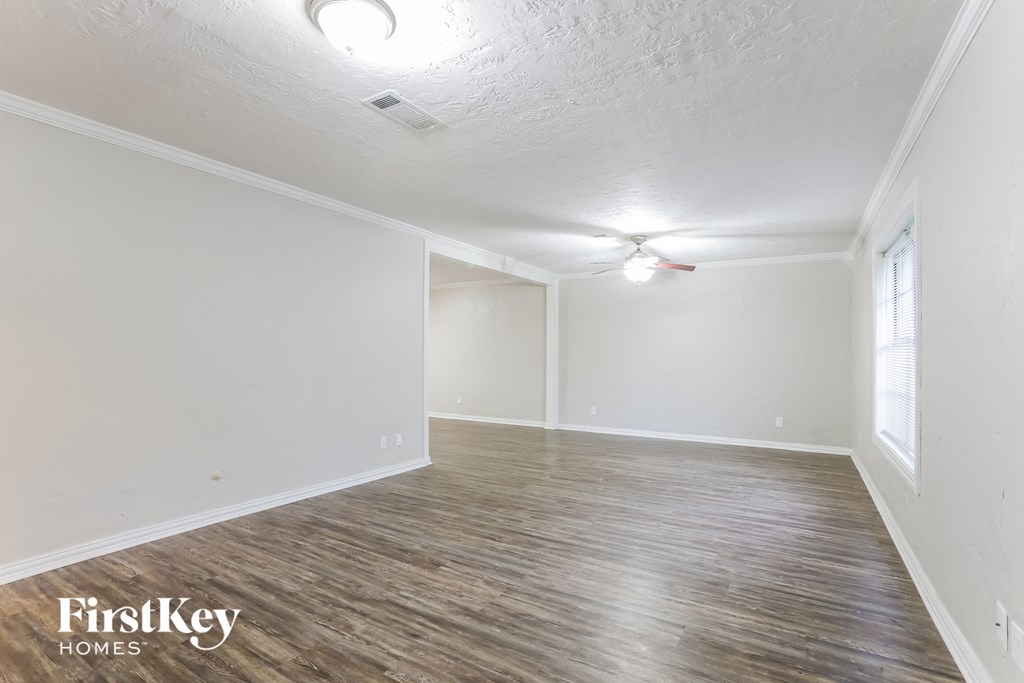 A room with wooden flooring and a ceiling fan.