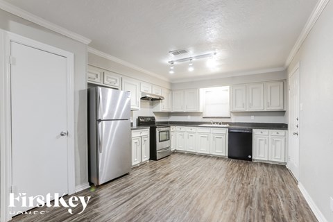 A kitchen with white cabinets and a stainless steel refrigerator.