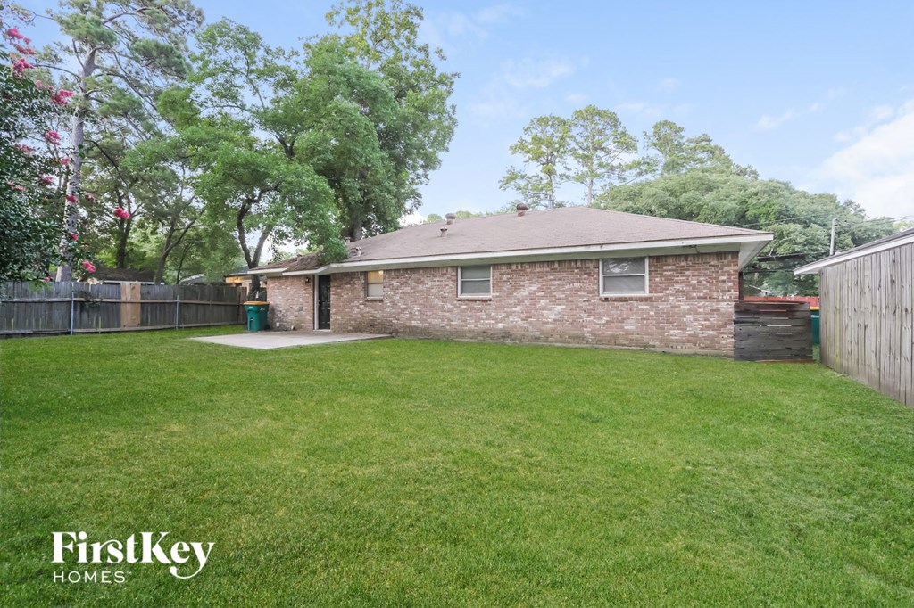 A house with a lawn and trees in the background.