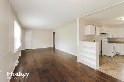 A spacious room with wooden floors and white walls.