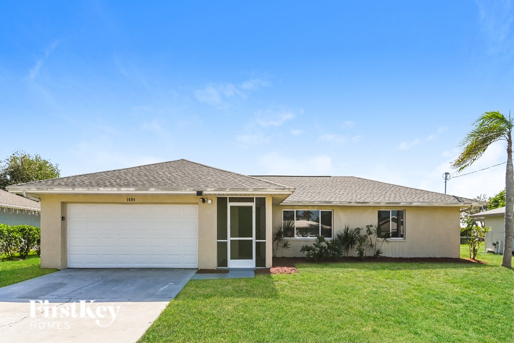 a house with a lawn and a palm tree