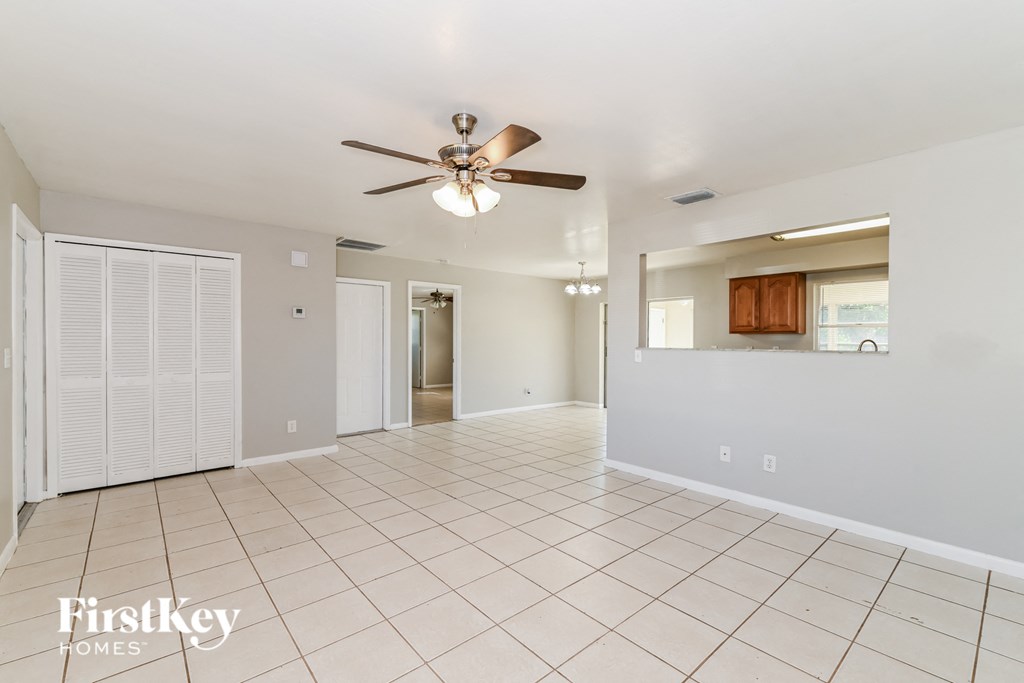 a clean and empty living room with a ceiling fan