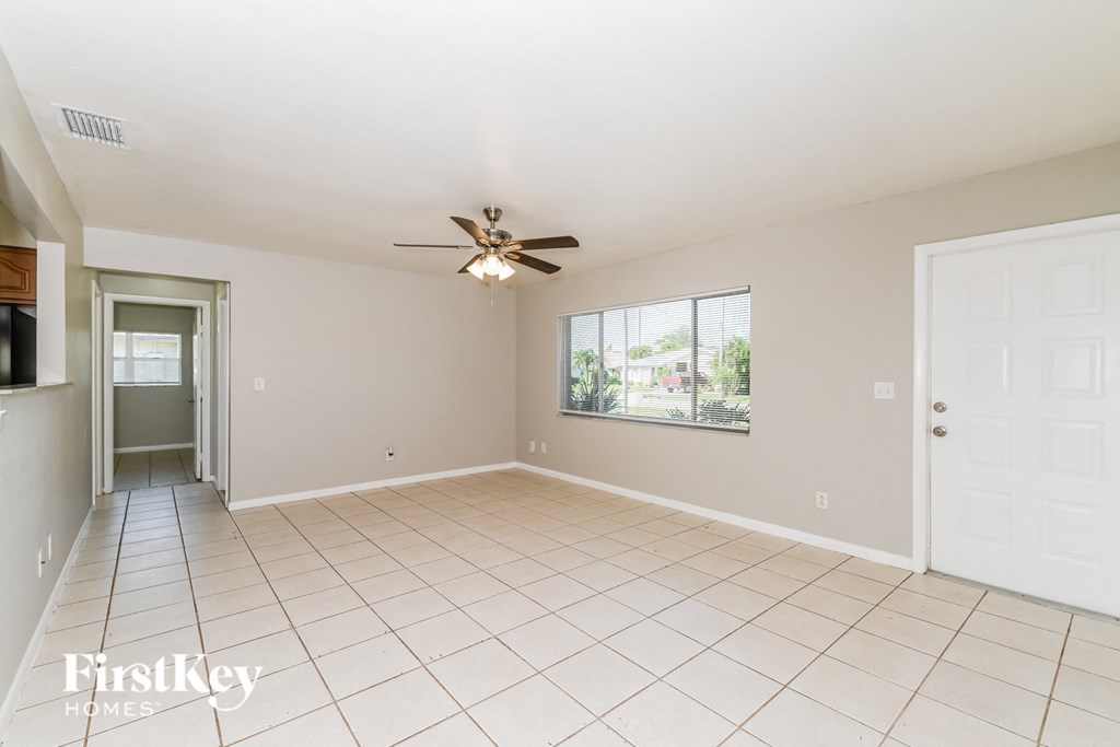 a clean and empty living room with a ceiling fan
