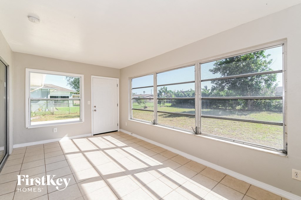 an empty living room with large windows overlooking a yard