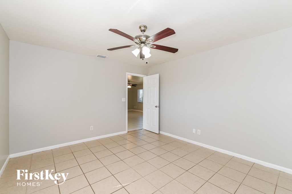 a clean and empty living room with a ceiling fan