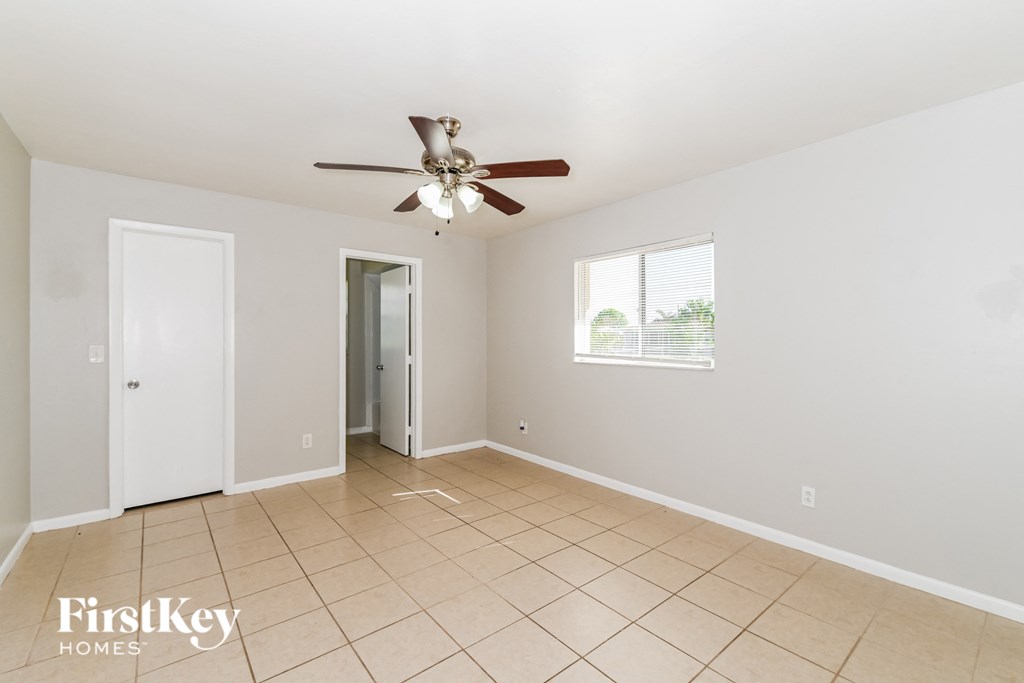 a clean and empty living room with a ceiling fan
