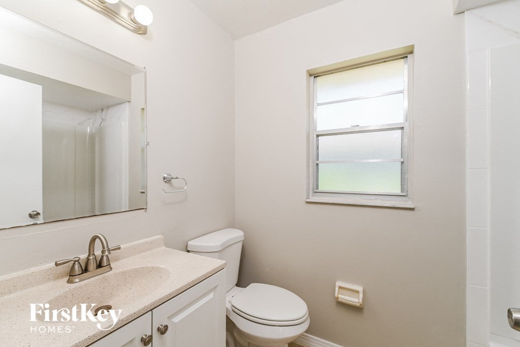 a bathroom with a toilet and a sink and a mirror