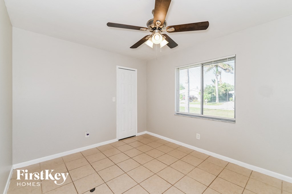 the living room has a ceiling fan and a tiled floor