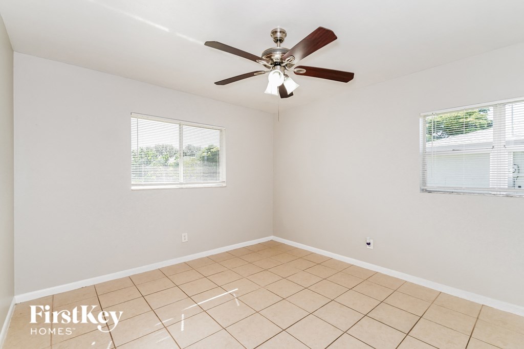 the living room has a ceiling fan and a tiled floor